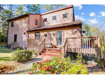 Charming two-story home with a wooden deck and colorful flower garden in the front yard at 1119 Palmyra Dr, Tega Cay, SC 29708