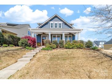 Charming blue two-story home with a welcoming front porch and landscaped front yard at 120 Keats Aly, Cramerton, NC 28032