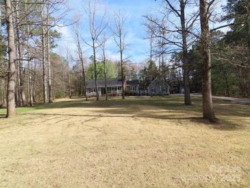 Charming gray home with a brick chimney and a large front yard perfect for outdoor activities at 1414 Farmstead Rd, Rock Hill, SC 29732