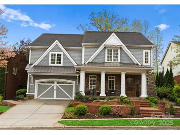 Charming two-story home with gray siding, white trim, columns, and a two-car garage at 21311 Baltic Dr, Cornelius, NC 28031