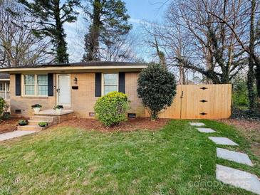 Charming brick home with a manicured lawn, landscaping and a welcoming entryway with steps at 4805 Horizon Cir, Charlotte, NC 28215