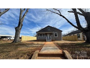 Charming single-story home with a front porch, freshly painted exterior, and a newly installed fence at 702 E Grover St, Shelby, NC 28150