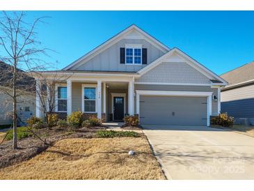 Charming home featuring a two-car garage, covered porch, and professionally landscaped front yard at 758 Latrobe Dr, Iron Station, NC 28080