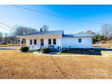 Charming single story home with inviting front porch, metal roof, and manicured landscaping at 129 38Th St, Hickory, NC 28601