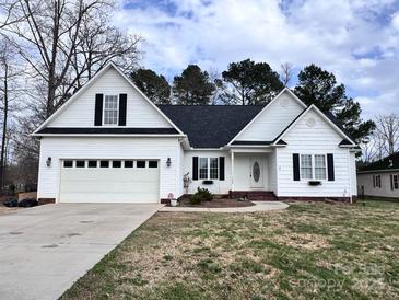 Charming white home featuring a two-car garage and well-maintained lawn at 145 Mcbride Dr, Rockwell, NC 28138