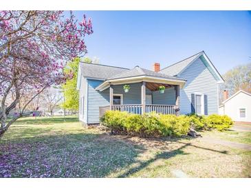 Charming two-story home with a cozy front porch, landscaping, and a blooming tree at 209 W Church St, China Grove, NC 28023