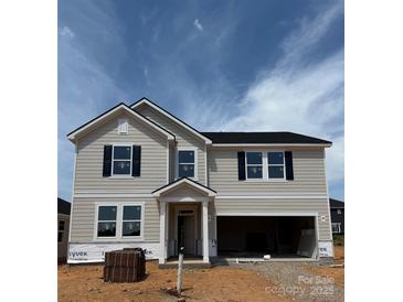 Two-story home featuring light siding, black shutters, an attached garage, and a welcoming front porch at 317 Maidstone Dr # 57, Monroe, NC 28110