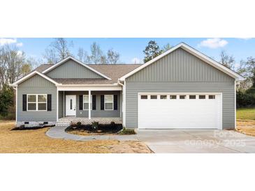 Charming single-story home with gray siding, a two-car garage, and a welcoming front porch at 325 East St, Heath Springs, SC 29058