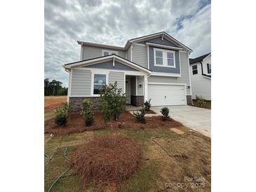 Charming two-story home with a two-car garage and beautifully designed landscaping at 346 Knotty Wood Dr # 71, Monroe, NC 28110