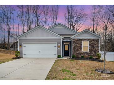 Charming single-Gathering home with stone accents, a two-car garage, and a well-manicured lawn at 10500 Bradstreet Commons Way, Charlotte, NC 28215