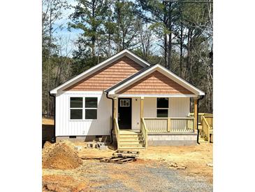 Charming single-story home with white siding, cedar shake accents, and a welcoming front porch, set on a wooded lot at 1228 Belmont Circle Rd, Lancaster, SC 29720