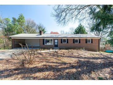 Charming brick home featuring a metal roof, level yard, and carport at 126 Regal Cir # 2122, Mooresville, NC 28115