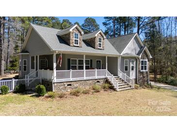 Charming two-story home with a inviting front porch, stone accents, dormers, and landscaped front yard at 1717 Deer Run Rd, Catawba, SC 29704