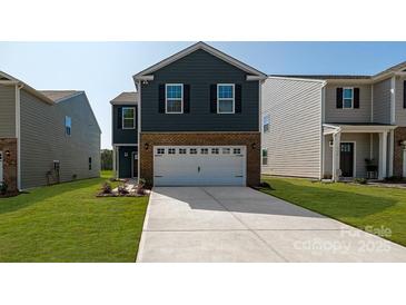 Charming two-story home with a brick and siding exterior, lush lawn, and two car garage at 3044 Ora Smith Rd, Lincolnton, NC 28092