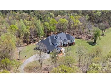 Aerial view of a large home with a well-manicured lawn surrounded by trees at 447 Willow Pond Ln, Hiddenite, NC 28636