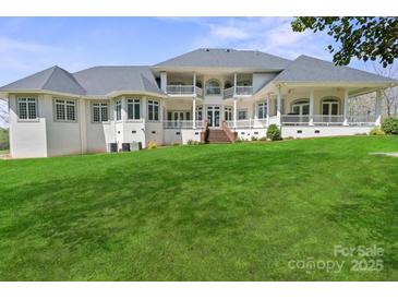 Expansive backyard with lush lawn, complementing the home's covered porch and large windows at 447 Willow Pond Ln, Hiddenite, NC 28636