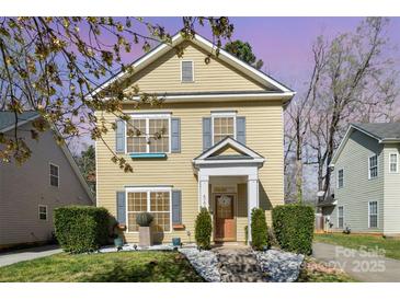 Charming two-story home with yellow siding, gray shutters, and a well-manicured front yard at 4741 Eaves Ln, Charlotte, NC 28215