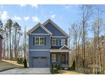 Beautiful two-story home with blue siding, gray accents, two-car garage, and a well-maintained landscaped yard at 615 W Stanly W St, Stanfield, NC 28163