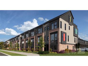 Modern townhome exteriors feature brick accents, dark trim, and colorful window details, set against a blue sky and green landscaping at 1041 Northend Dr # 33, Charlotte, NC 28206