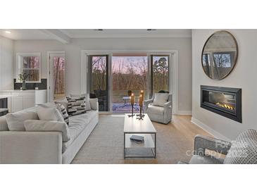 Bright living room with fireplace, neutral decor, and sliding doors to the outdoor patio at 1132 Meander Ln, Waxhaw, NC 28173