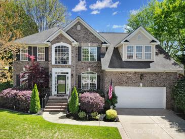 Charming two-story brick home featuring a well-manicured lawn and a welcoming front porch at 227 Coralstone Dr, Fort Mill, SC 29708
