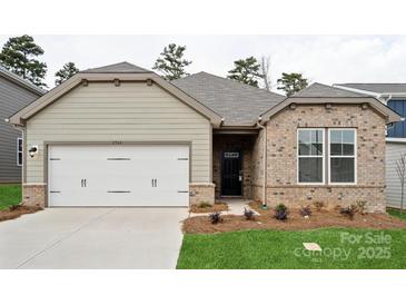 Charming single-story home featuring a two-car garage, brick accents, and a welcoming front entrance at 2577 Blue Sky Meadows Dr, Monroe, NC 28110