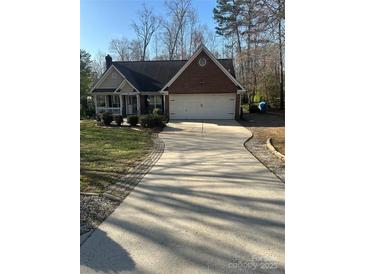 Charming brick home with a two-car garage and a long driveway at 7144 Hunters Bluff Dr, Denver, NC 28037