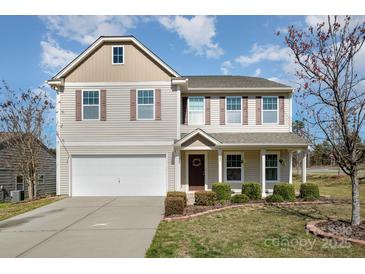 Charming two-story home with vinyl siding, shutters, and a well-maintained front yard at 887 Pointe Andrews Dr, Concord, NC 28025