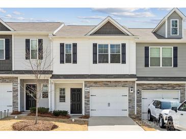 Charming two-story townhouse featuring a one-car garage and stone accents at 10036 Brittondale Ln, Charlotte, NC 28215