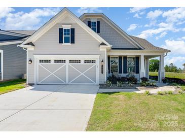 Charming exterior with a two-car garage, lovely front porch and beautiful landscaping at 10421 Superb Ln, Charlotte, NC 28215