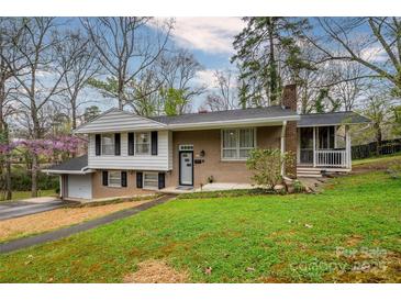 Charming home featuring a well-maintained lawn, brick facade, attached garage, and a screened-in porch at 107 Wedgewood Ne Cir, Concord, NC 28025
