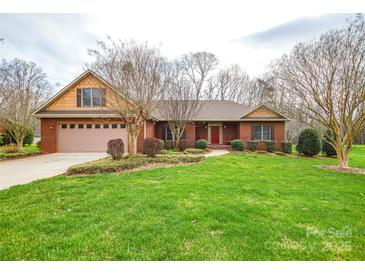 Charming brick home featuring a well-manicured lawn, established landscaping, and attached two-car garage at 161 Seven Springs Loop # 11, Statesville, NC 28625