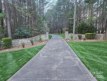 Long driveway leading to a beautiful home, flanked by stone walls and lush greenery at 1832 Marthas Vineyard Rd, York, SC 29745