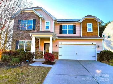 Charming two-story home boasts a mix of stone and siding, complemented by a two-car garage at 1923 Caprington Dr, Fort Mill, SC 29707