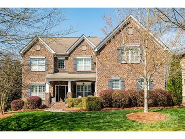 Charming brick home featuring a manicured lawn and beautifully landscaped flower beds at 4225 Jasmin May Dr, Charlotte, NC 28226