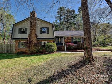 Charming brick home with a gambrel roof, chimney, and lush front lawn at 4522 Chuckwood Dr, Mint Hill, NC 28227