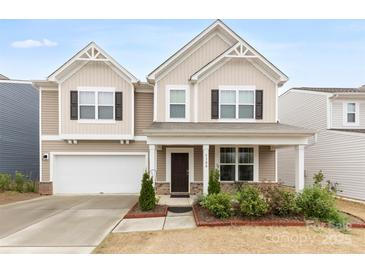 Charming two-story home boasts a well-manicured lawn, covered porch, and attached two car garage at 5108 Puclerton Dr, Charlotte, NC 28215
