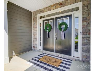 Inviting double front door with stone accents, welcome mat, and wreaths at 6276 Artigas Dr, Fort Mill, SC 29707