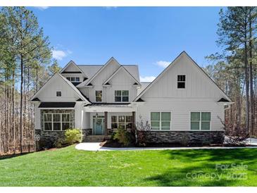 Charming two-story home with a manicured lawn, stone accents, and a welcoming blue front door at 7322 Bay Ridge Dr, Denver, NC 28037