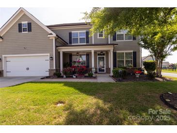Charming two-story home with a well-manicured lawn and inviting front porch at 1501 Allegheny Way, Waxhaw, NC 28173