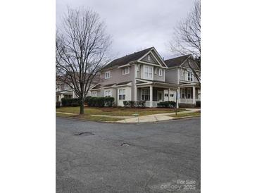 Charming two-story townhouse featuring a covered porch, manicured landscaping, and neutral toned siding at 18224 Taffrail Way, Cornelius, NC 28031