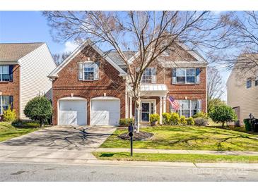 Charming two-story brick home with a well-manicured lawn, two-car garage, and an inviting entrance at 2014 Arbor Crest Ct, Charlotte, NC 28262