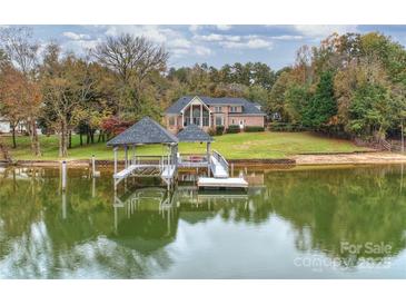 Expansive waterfront property with a private dock, gazebo and lush, mature trees surrounding the stately brick home at 2045 Driftwood Cir, Fort Mill, SC 29708
