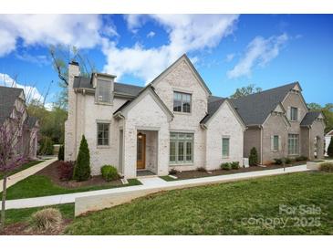 Charming white brick home featuring a manicured lawn, lush landscaping, and inviting entry at 3119 Knowlton Ln, Charlotte, NC 28205