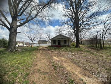 Charming one-story home featuring mature trees, a front porch, and a spacious yard at 4349 Roberta Rd, Concord, NC 28027