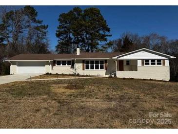 Charming one-story home with white painted brick, brown roof, and attached garage at 614 Hazelwood Dr, Albemarle, NC 28001