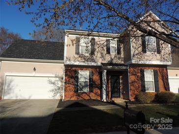 Charming two-story home featuring a brick facade, neutral siding, and an attached two-car garage at 7814 Rolling Meadows Ln, Huntersville, NC 28078
