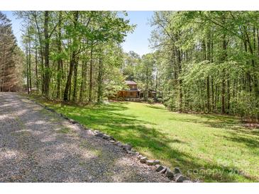 View of a charming wooded lot and log home at 1007 Mistywood Ln, Concord, NC 28027