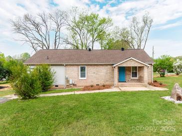 Charming single-story brick home with a bright blue front door and a well-manicured lawn at 1401 Birch St, Kannapolis, NC 28081