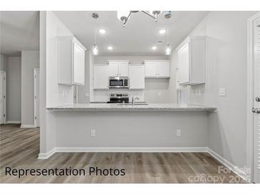 Bright kitchen features white cabinetry, granite counters, and stainless steel appliances at 2019 Mcdonald Dr, Charlotte, NC 28216